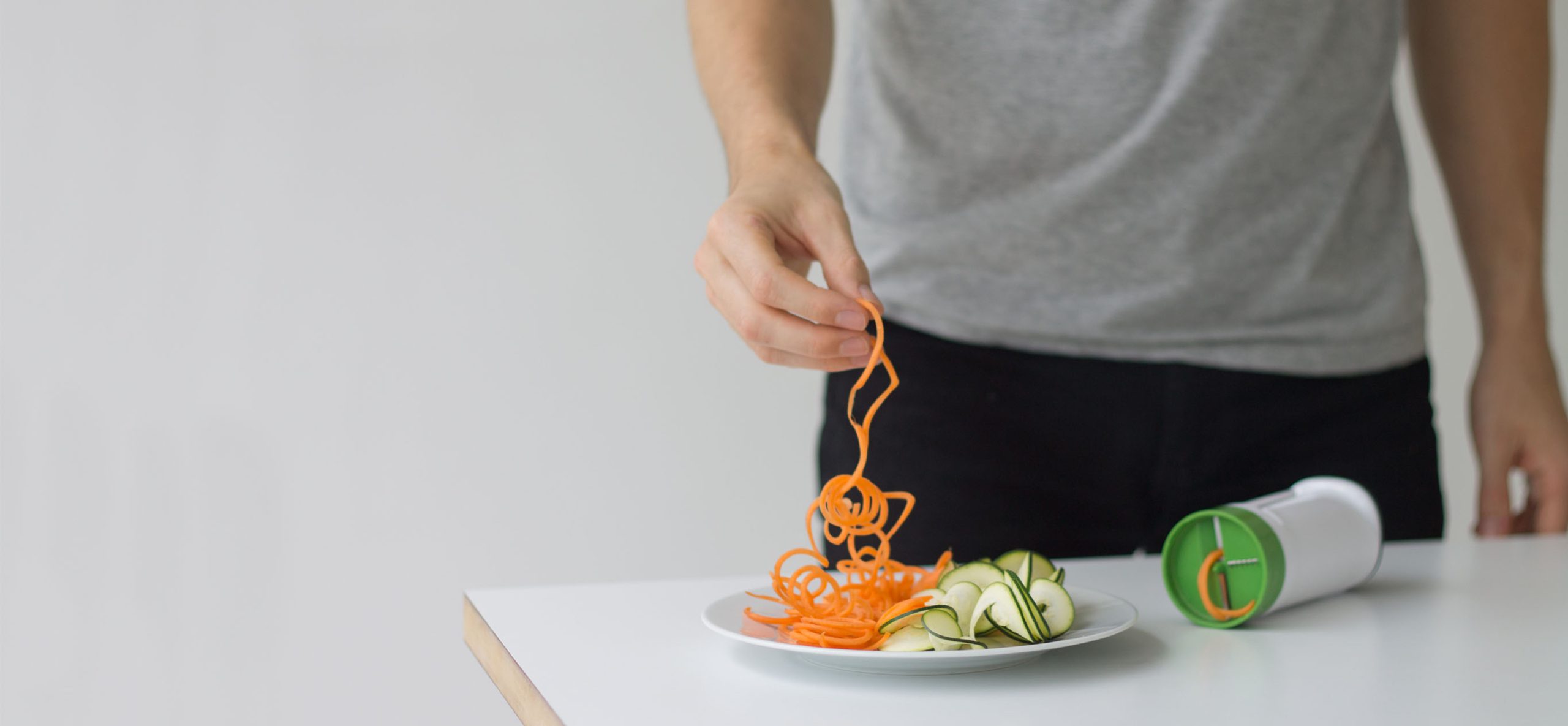 man picking up spiralised food from a plate