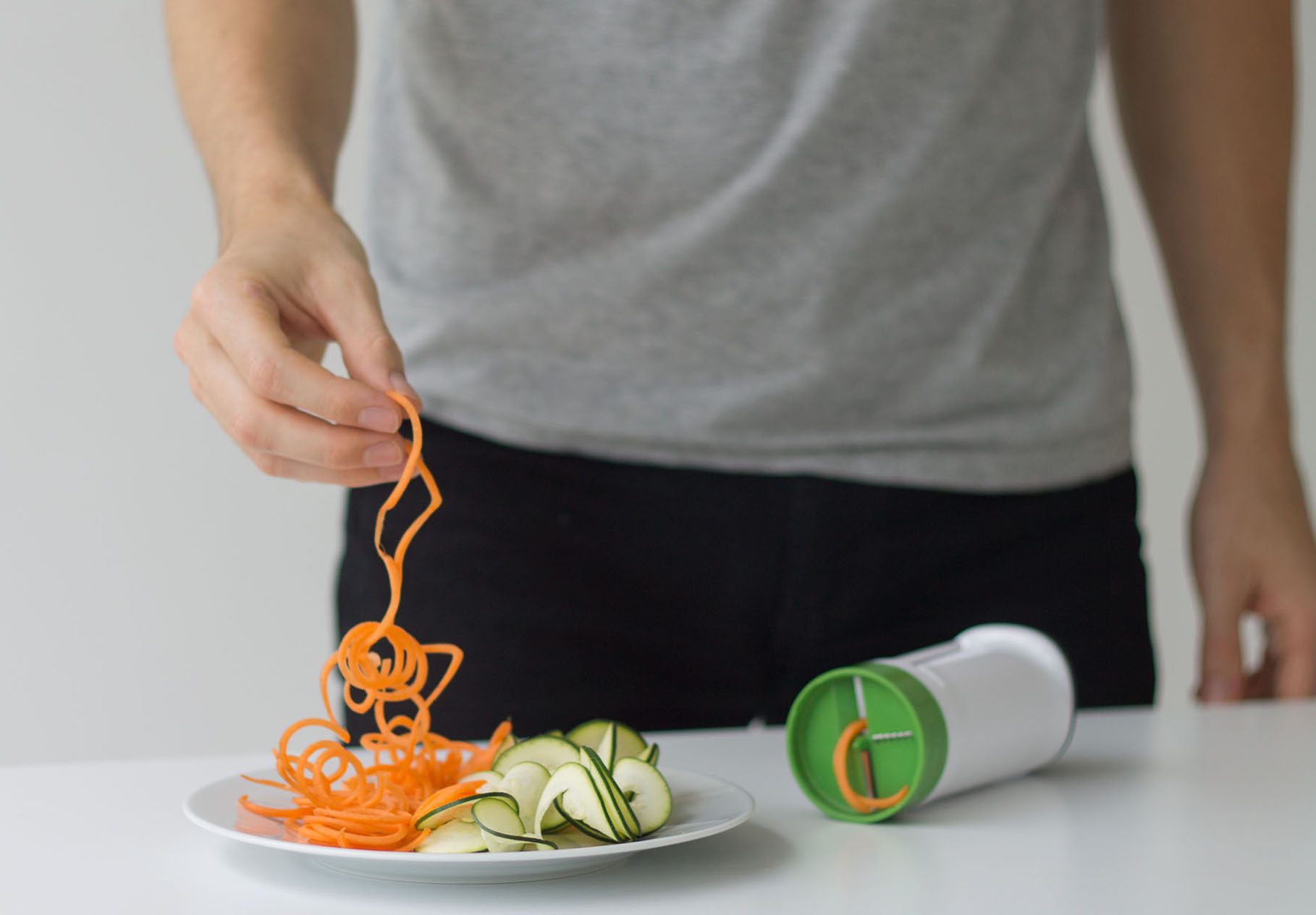 man picking up spiralised food from a plate