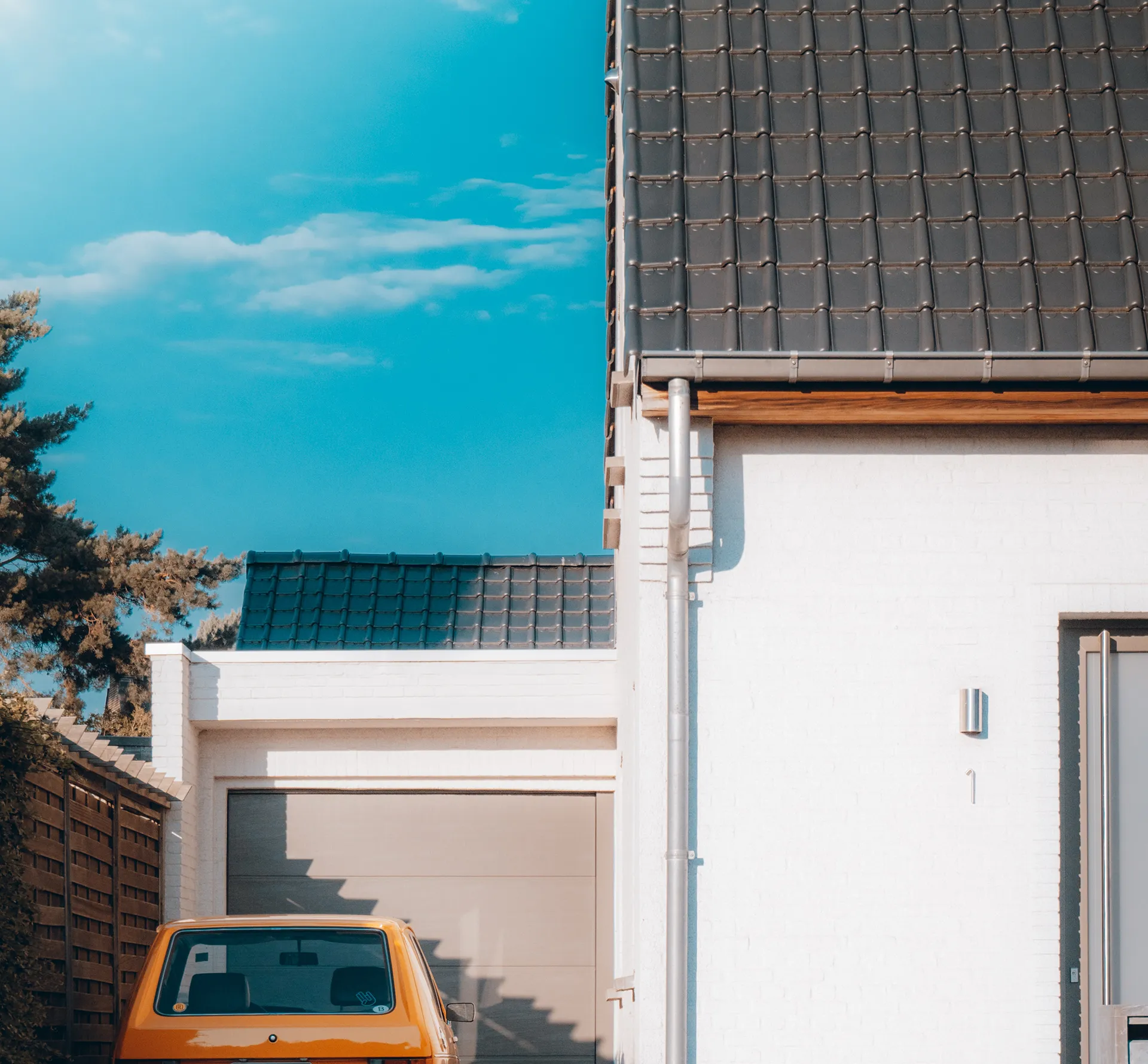 Driveway with orange car in front of garage door