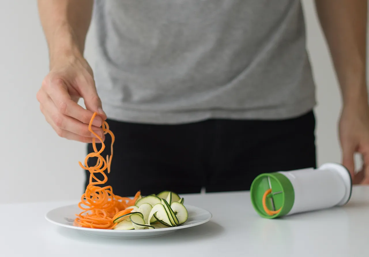 Spiralized carrot being lifted up from a plate
