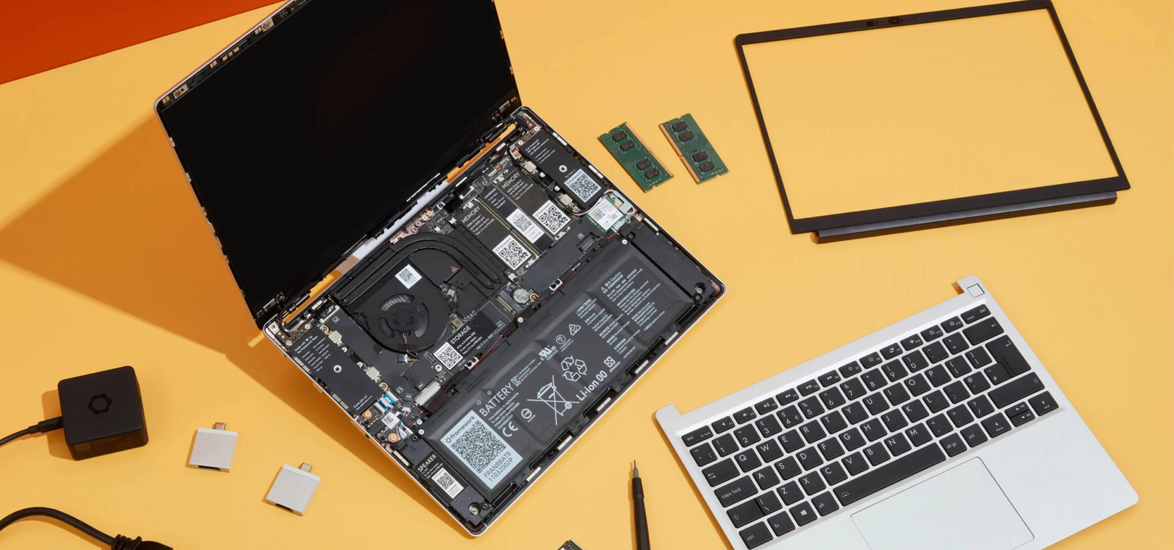 Parts from a Framework laptop on a yellow background