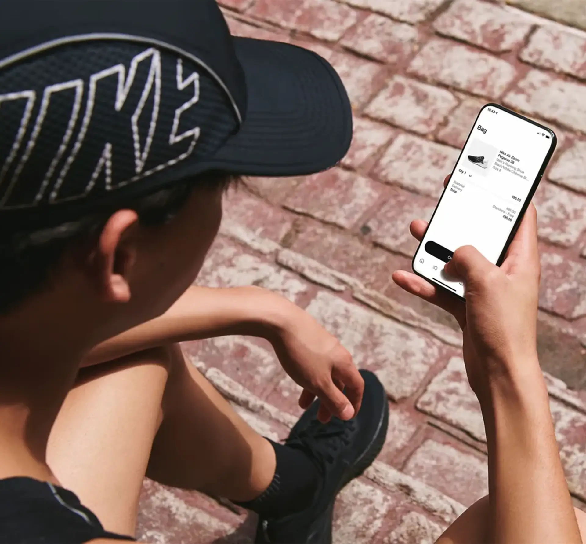 man in a cap using the Nike app on his phone