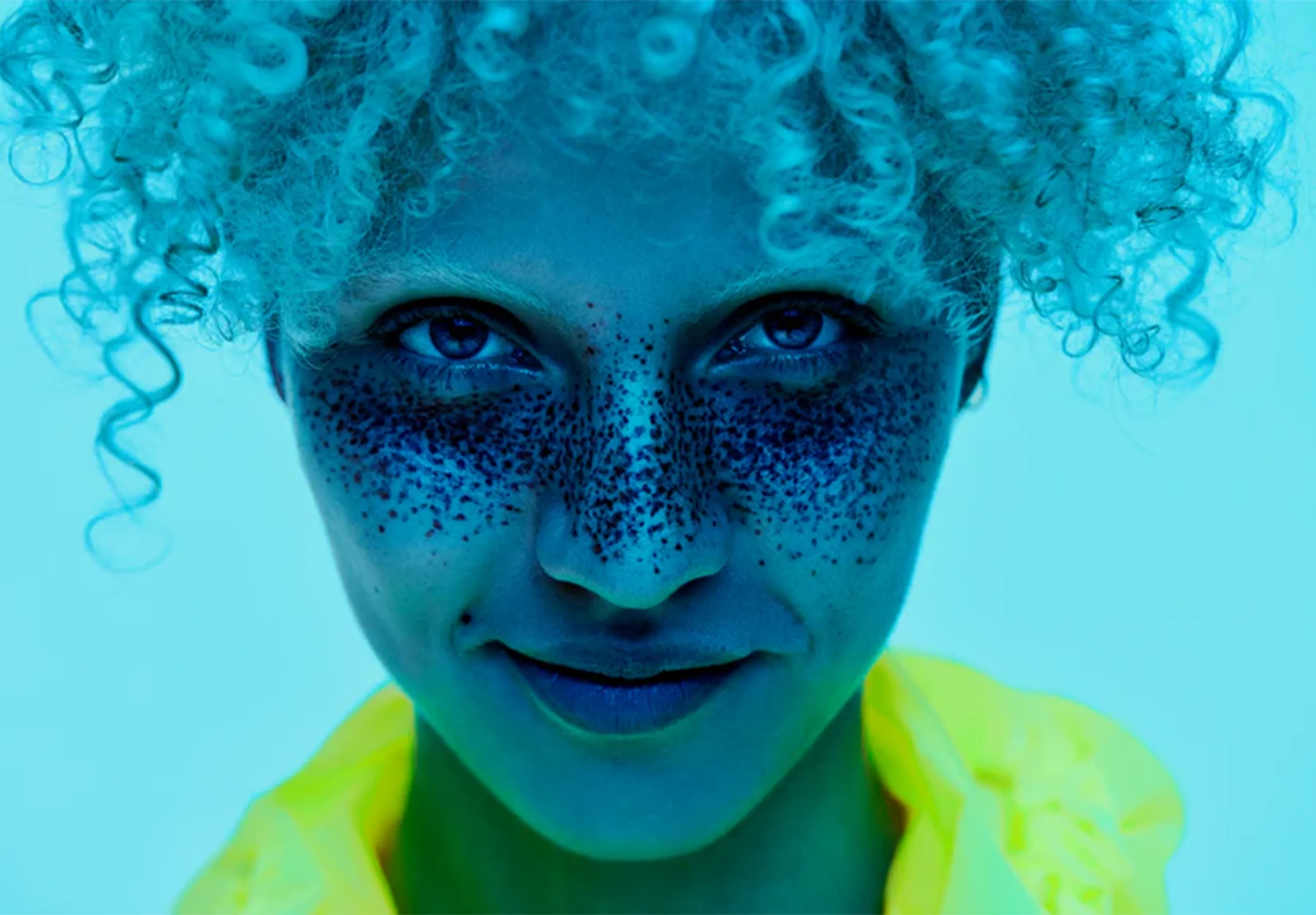 Woman with curly blonde hair on a blue background