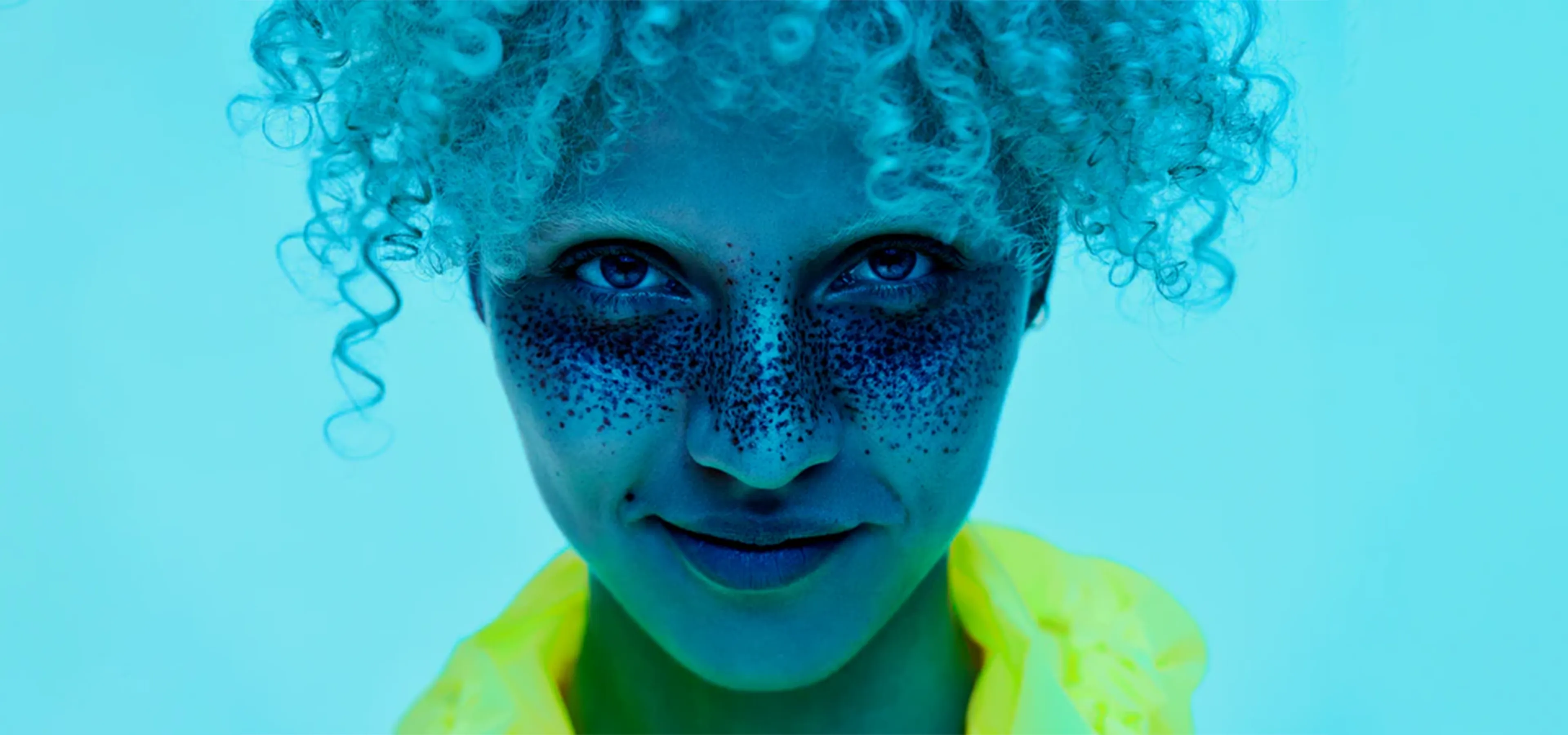 Woman with curly blonde hair on a blue background