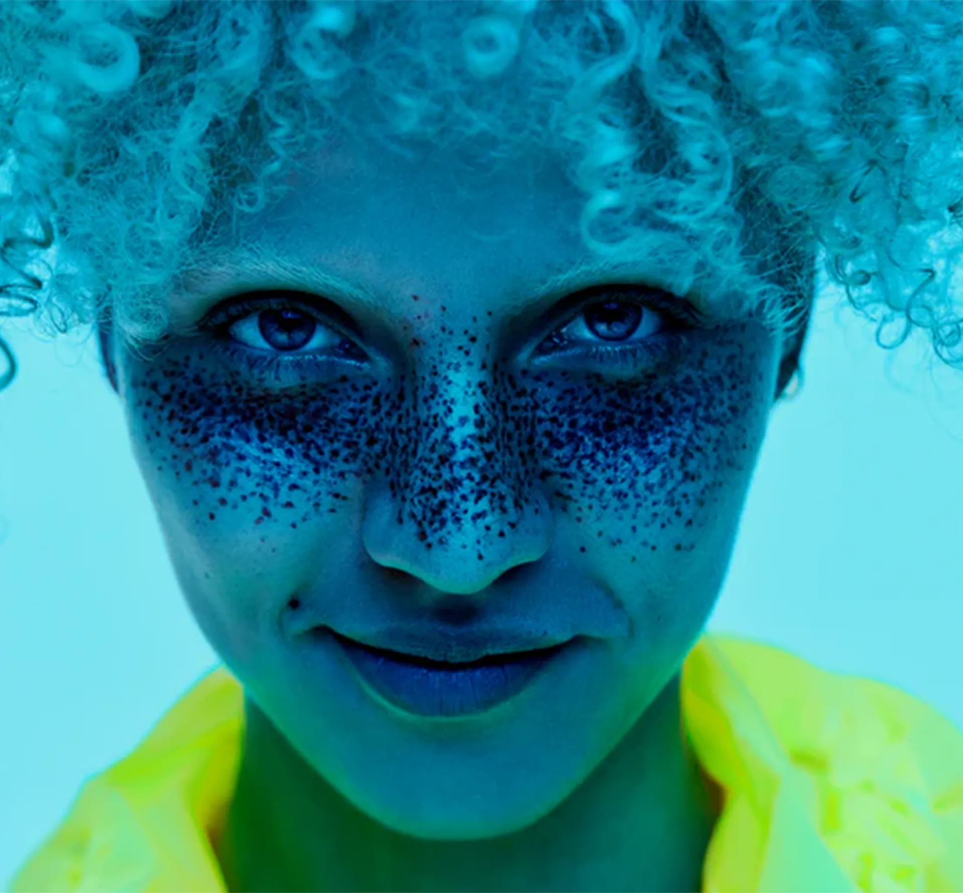 Woman with curly blonde hair on a blue background