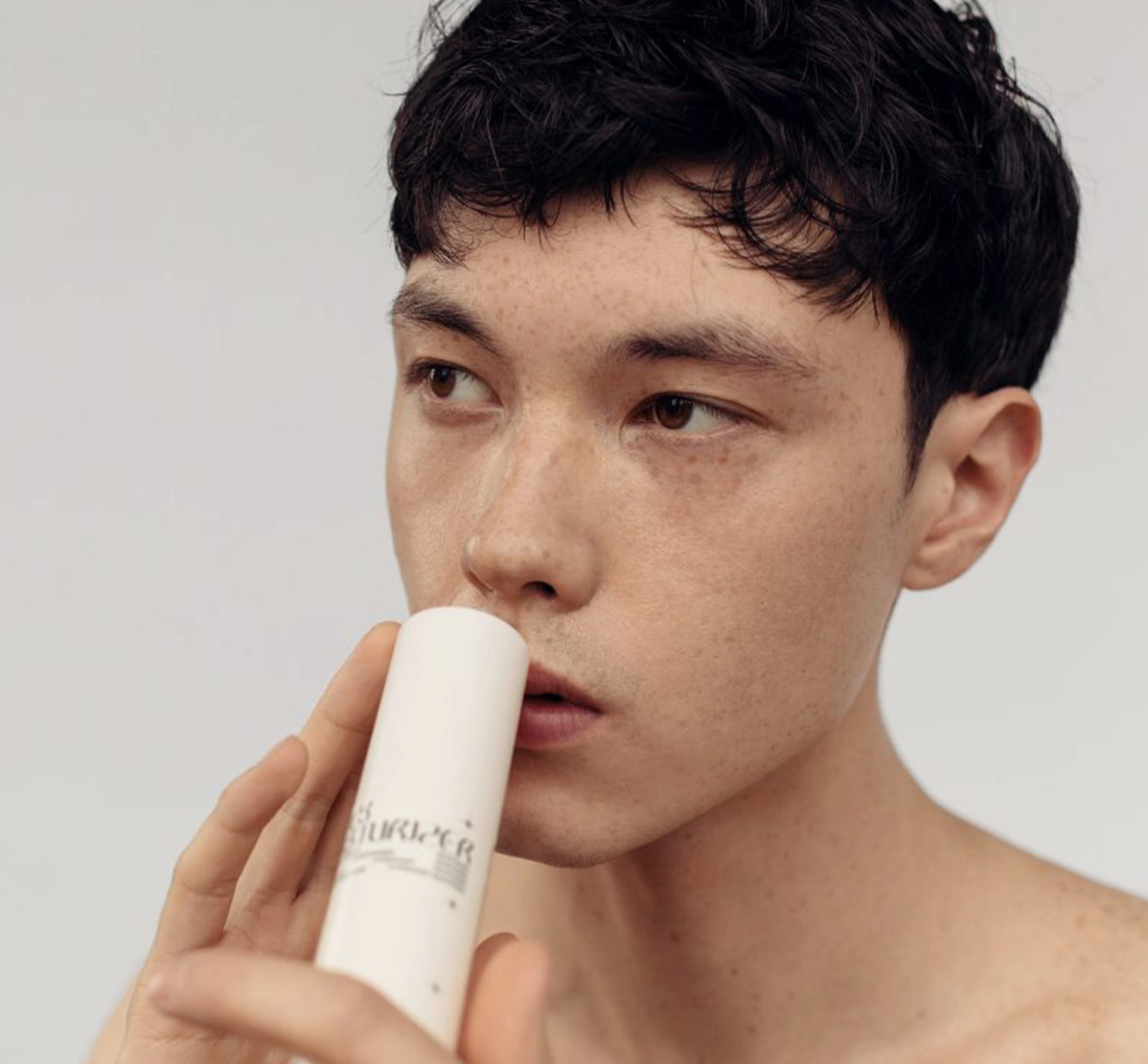 Man smelling cosmetics