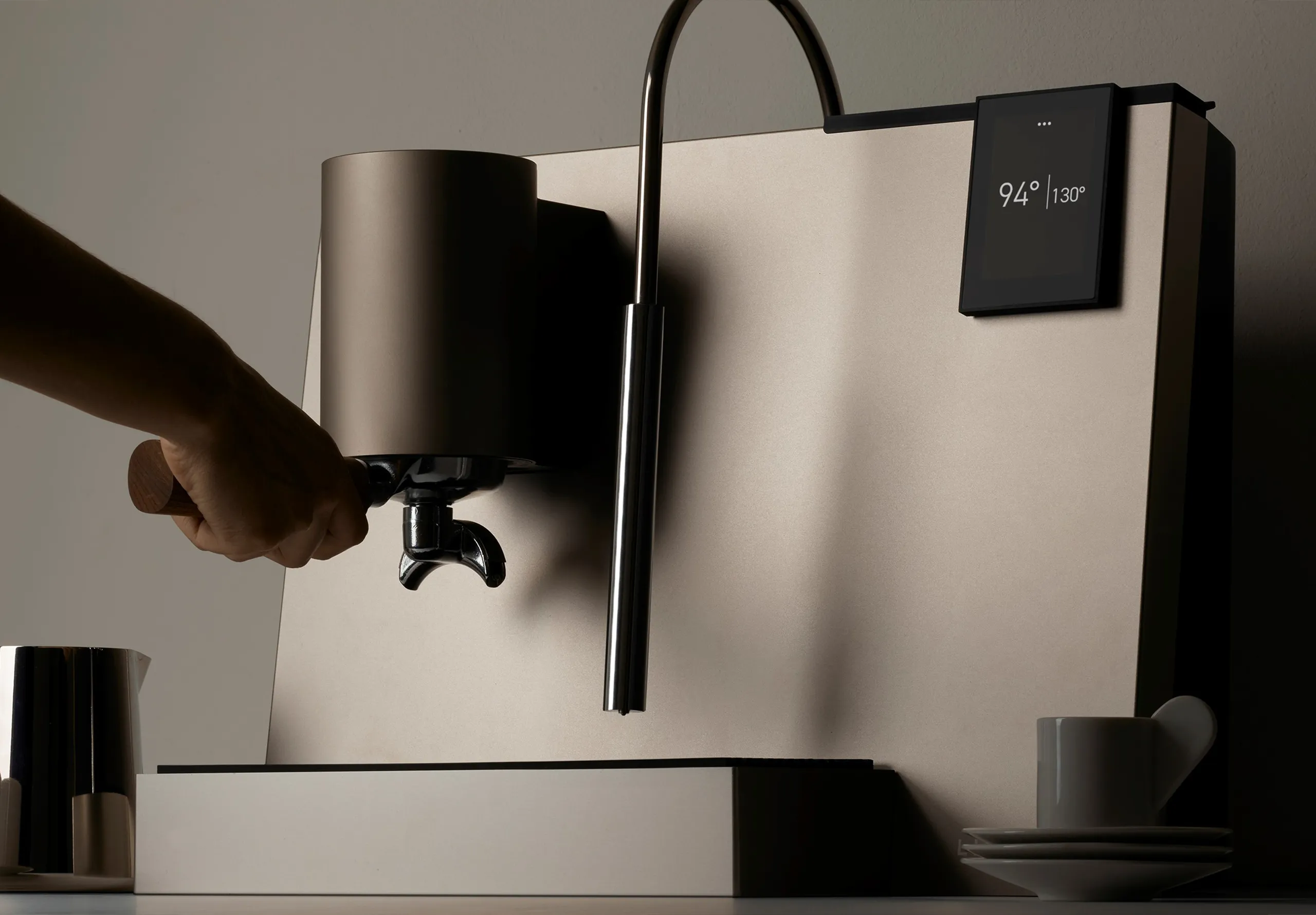 hand holding the portafilter handle of a coffee machine
