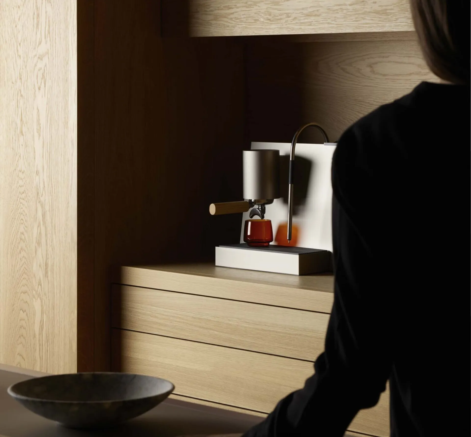 woman walking in kitchen with coffee machine on the worktop