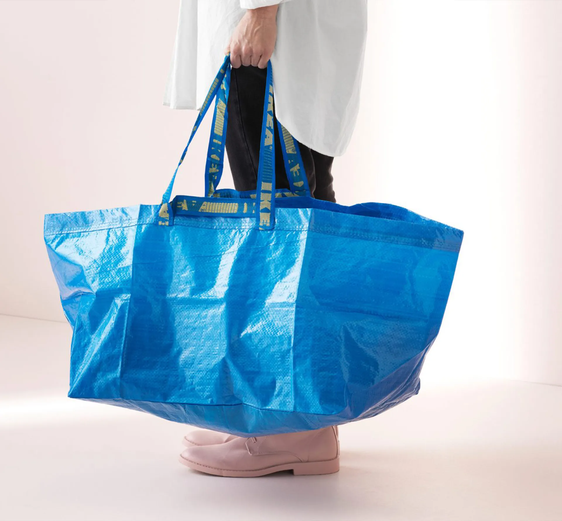 Man holding a blue Ikea bag