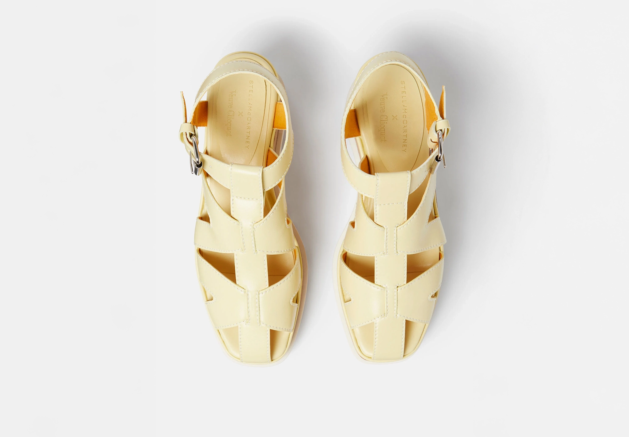 A pair of cream colour sandals on white background