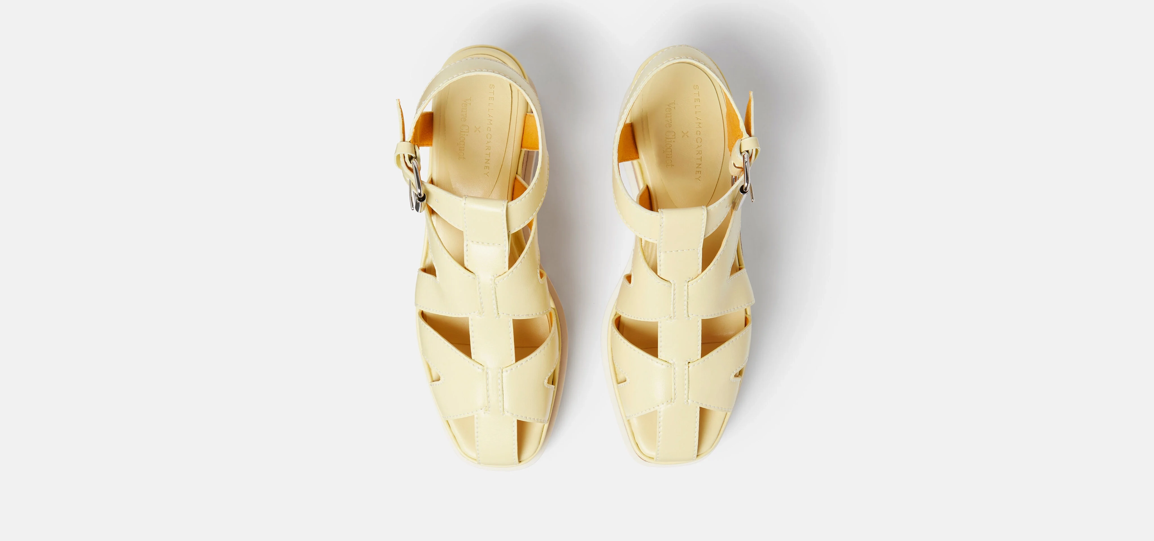 A pair of cream colour sandals on white background
