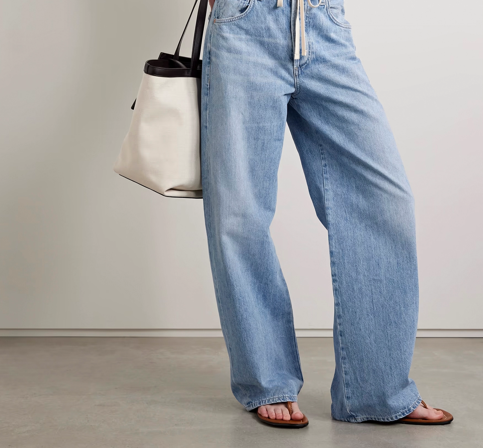 Woman in jeans with a white handbag