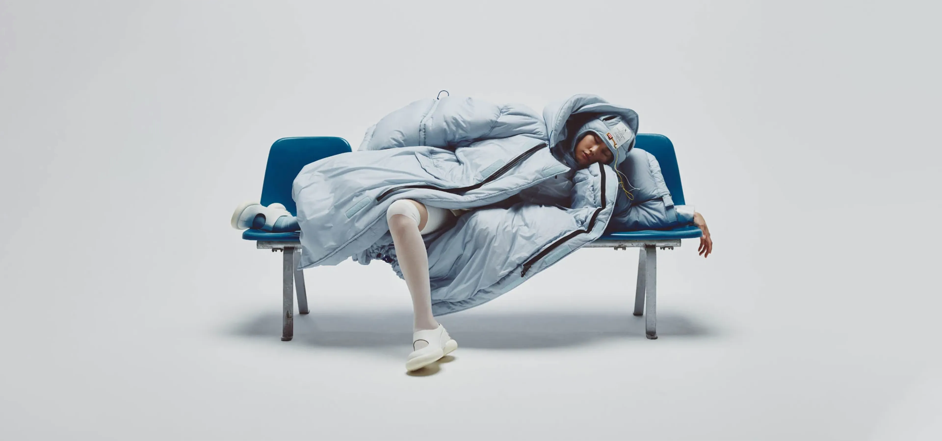 A person in blue duvet jacket lounging on a chair