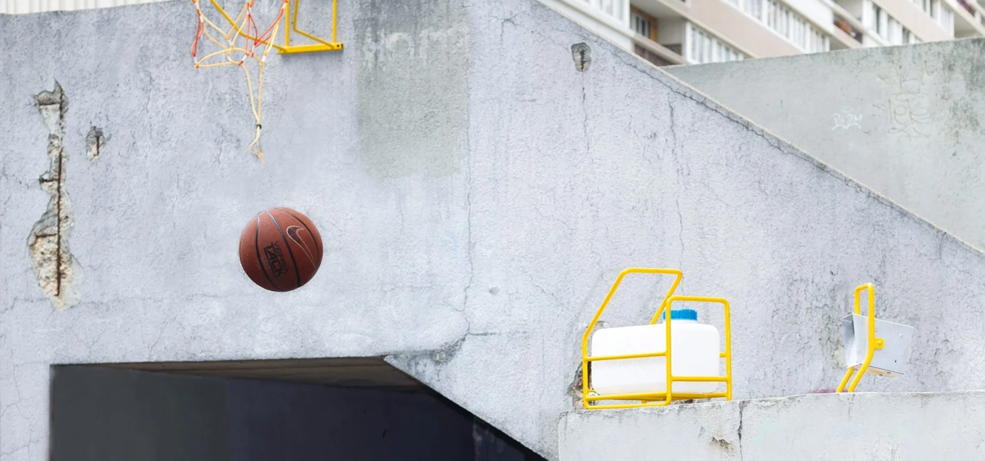 Basketball hoops and lighting near a tower block