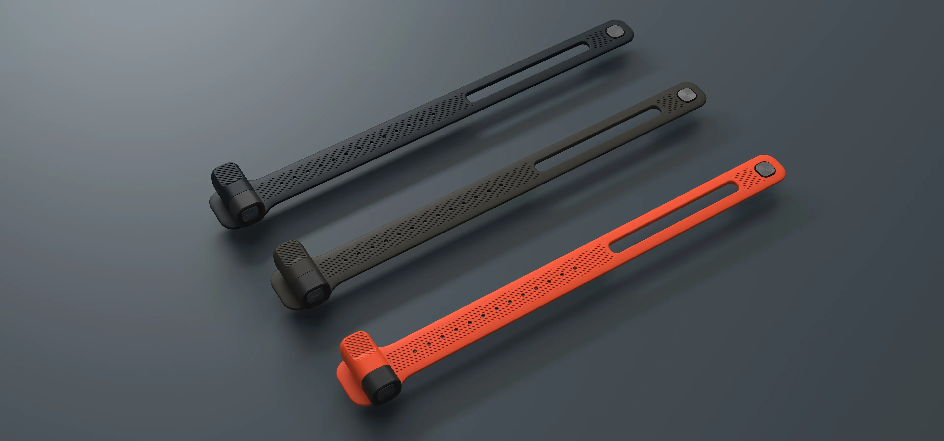 an image showing three wearable torches in a diagonal composition. The product are shown in three colour bright orange, heath green and slate blue.