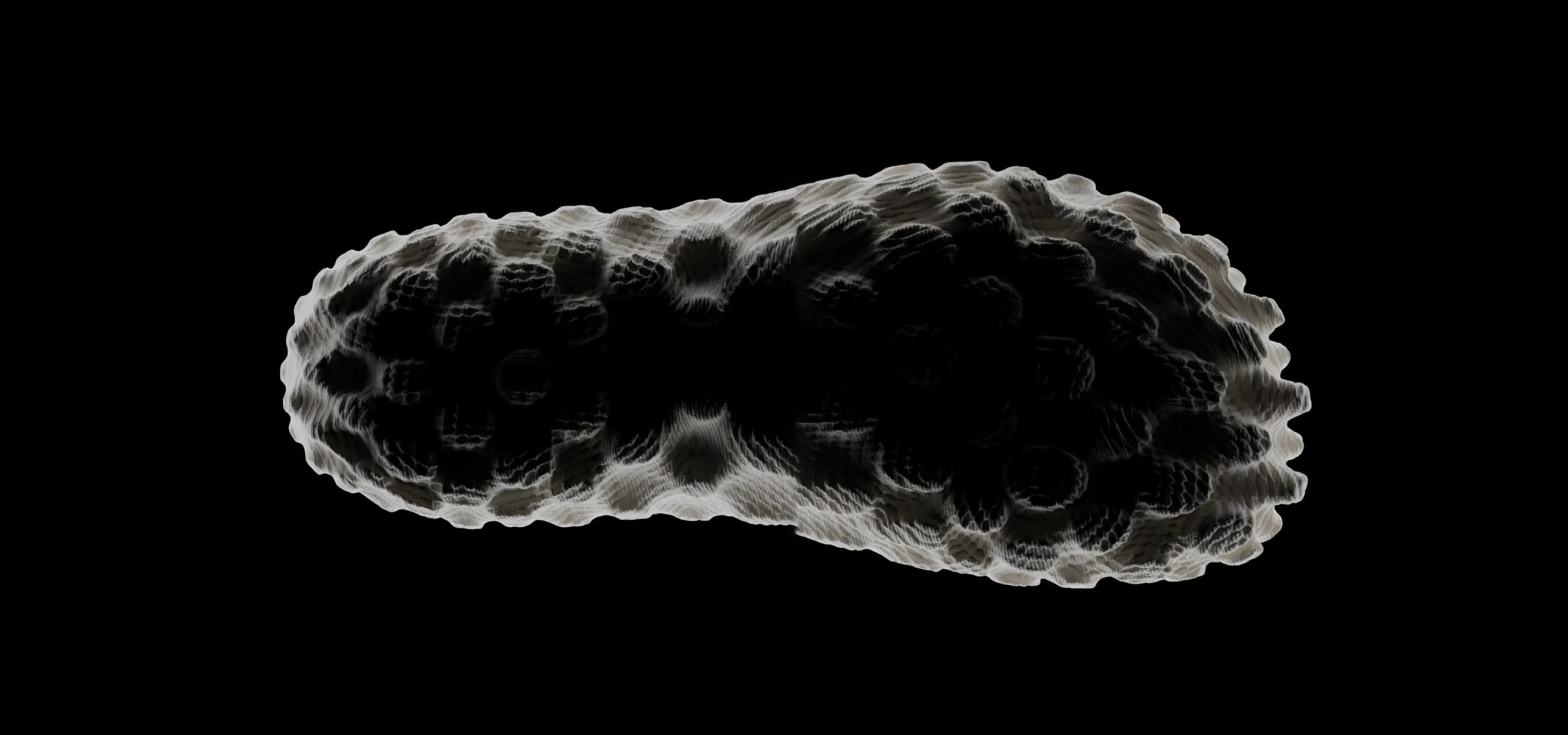 Underside view of rubber sole of shoe on black background