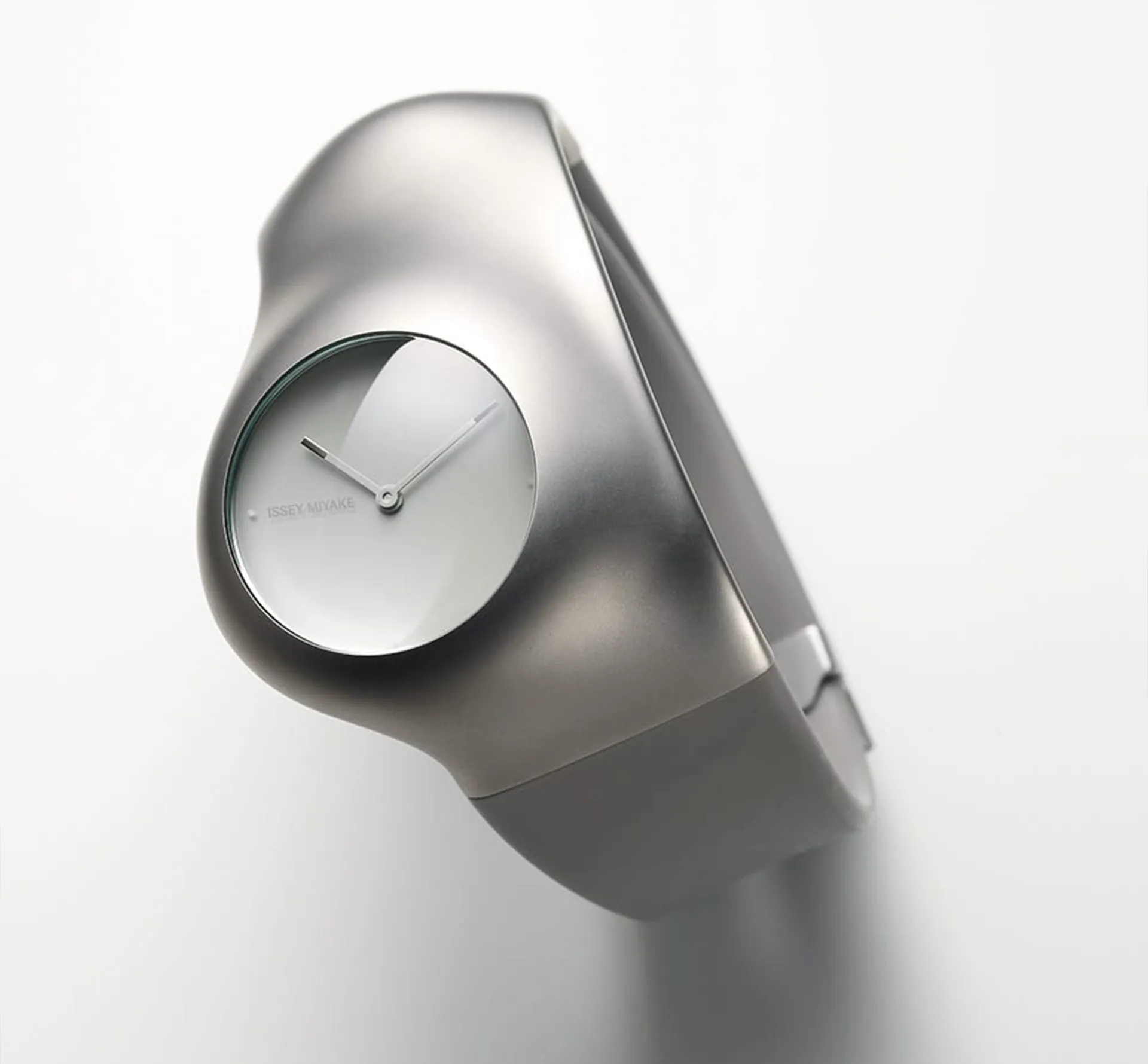 A silver watch on light grey background